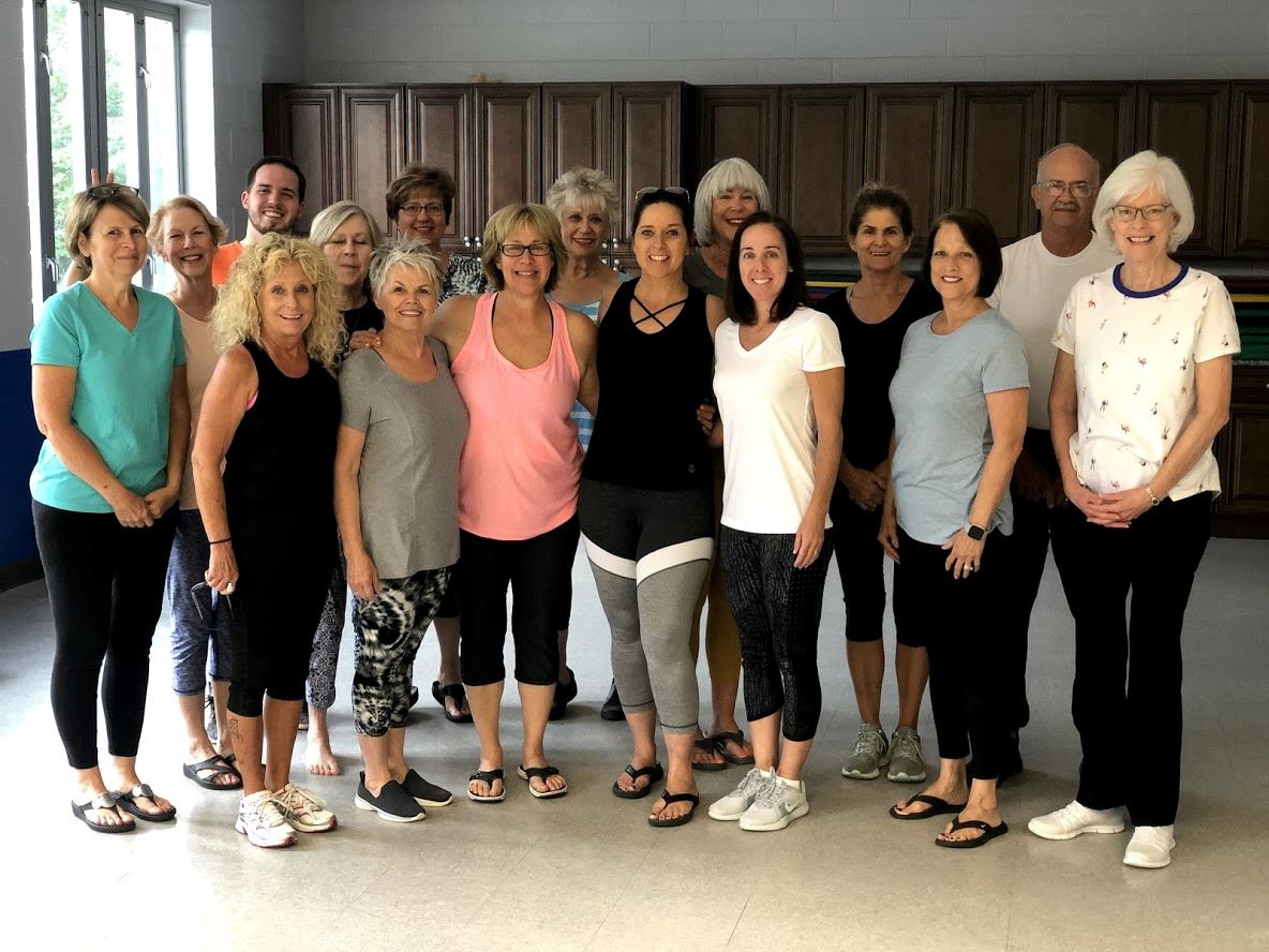Group of all ages smiling after yoga class